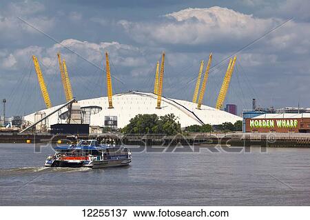 Stock Photo - View of the River Thames, the O2 Arena and a transport for London commuter boat; London, England. Fotosearch