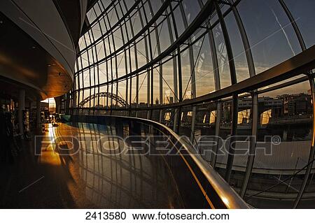 Stock Image - View of the River Tyne and bridge at sunset from the windows of a building on the waterfront; Gateshead, Tyne and Wear, England. Fotosearch