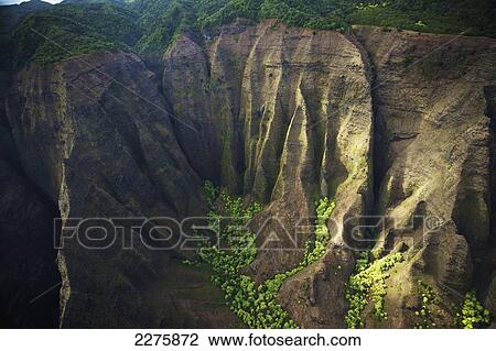 View of the rugged landscape along the coast of a hawaiian island, Na Pali coast; Kauai, Hawaii, United States of America View Large Photo Image Stock Image - View of the rugged landscape along the coast of a hawaiian island, Na Pali coast; Kauai, Hawaii, United States of America. Fotosearch