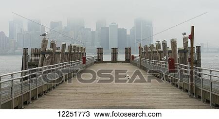 View of the skyline through the fog from a wooden pier; New York City, New York, United States of America View Large Photo Image Stock Image - View of the skyline through the fog from a wooden pier; New York City, New York, United States of America. Fotosearch