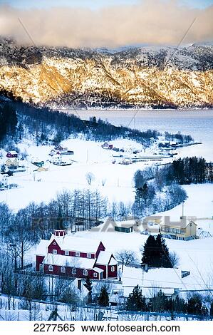 Stock Photography - View of the village, Fjord and mountains with the sun setting over the mountains; Ortnevik, Sognefjord, Norway. Fotosearch