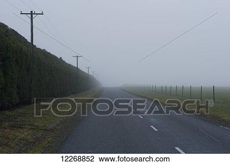 Stock Image - View of Waimarama Road on a foggy overcast day, Methven, New Zealand. Fotosearch