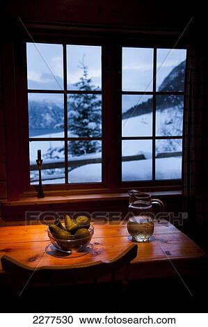 Stock Image - View out of the window of a Brekke rental cabin in winter with fruit and juice on the table; Ortnevik, Sognefjord, Norway. Fotosearch
