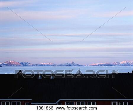 Stock Photograph - View Over Rooftop Towards Coastline And Mountains. Fotosearch