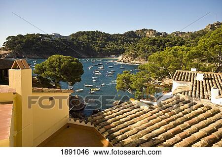 Stock Photograph - View Over Rooftops Of Fornells Beach In Begur. Fotosearch
