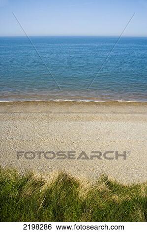 Stock Photograph - View over the cliff edge, above the beach. Weybourne beach. Weybourne, Norfolk, UK. Fotosearch