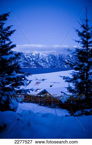 Stock Photo - View over the village, fjord and mountains with Brekke rental cabins at dusk; Ortnevik, Sognefjord, Norway. Fotosearch