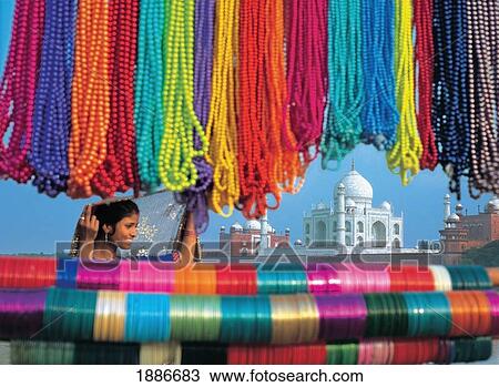 Stock Image - View Through Bead Stall Towards Woman And Taj Mahal. Fotosearch