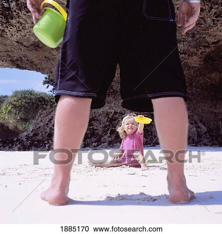 View Through Father's Legs Of Child Playing In The Sand View Large Photo Image Stock Image - View Through Father's Legs Of Child Playing In The Sand. Fotosearch