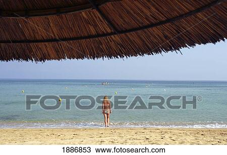 View Through Grass Roofed Umbrella Of Woman On Beach View Large Photo Image Stock Image - View Through Grass Roofed Umbrella Of Woman On Beach. Fotosearch
