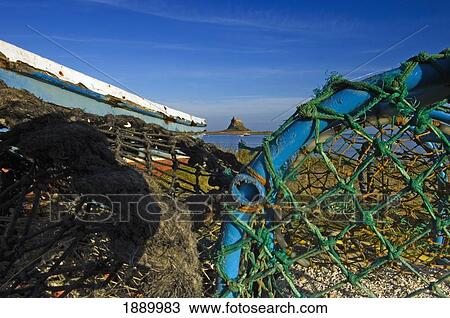 Stock Image - View To Lindisfarne Castle On Holy Island With Fishing Nets In The Foreground.. Fotosearch