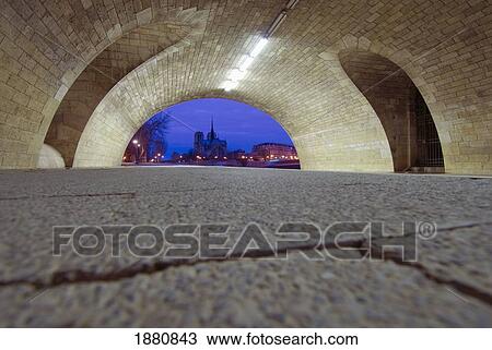 Stock Image - View Under Bridge To Notre Dame Cathedral At Dawn.. Fotosearch