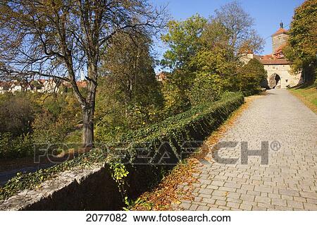 Stock Image - Vines Growing On A Stone Ledge Along A Path Leading To A Town Gate; Rothenburg Ob Der Tauber Bavaria Germany. Fotosearch