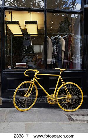 Stock Image - Vintage Bicycle In Front Of Window Display; England, United Kingdom. Fotosearch
