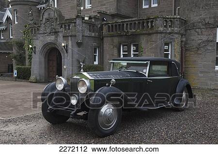Stock Image - Vintage Black Car Parked Outside A Large Home; Perthshire Scotland. Fotosearch