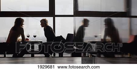 Stock Image - Visitors enjoy a drink on the twenty-sixth floor of the Reval Hotel Skyline Bar; Riga, Latvia. Fotosearch