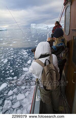 Stock Photo - Visitors On A Midnight Cruise Around The Ilulissat Ice Fjord, One Of Unesco World Heritage Sites. Greenland.. Fotosearch