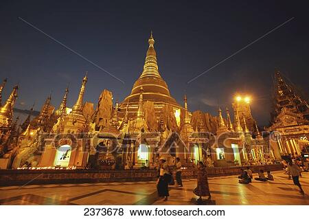 Visitors walk around Shwedagon Pagoda at sunset; Yangon, Burma View Large Photo Image Stock Photo - Visitors walk around Shwedagon Pagoda at sunset; Yangon, Burma. Fotosearch