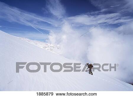 Stock Photo - Walker Climbing Up Snowy Slope In The Sierra Nevada Mountains. Fotosearch