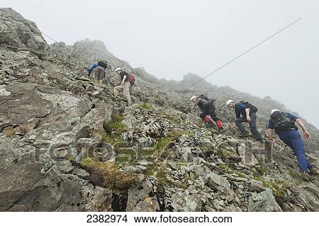 Walkers ascending steep rock near the top of Sgurr Alasdair in the Black Cuillin; Isle of Skye, Scotland View Large Photo Image Picture - Walkers ascending steep rock near the top of Sgurr Alasdair in the Black Cuillin; Isle of Skye, Scotland. Fotosearch