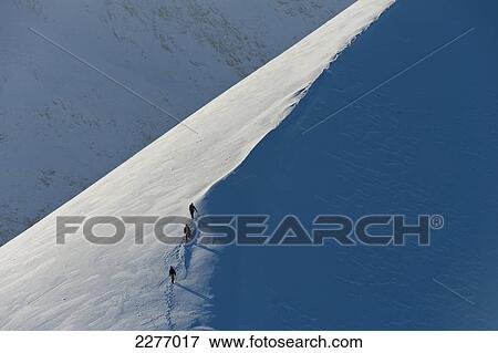 Stock Photo - Walkers climbing snowy ridge of Sgorr Dhearg in winter near Glen Coe; Highlands, Scotland. Fotosearch