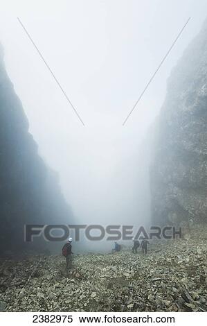 Stock Photography - Walkers descending The Great Stone Chute in the mist, from near the top of Sgurr Alasdair, Black Cuillin; Isle of Skye, Scotland. Fotosearch