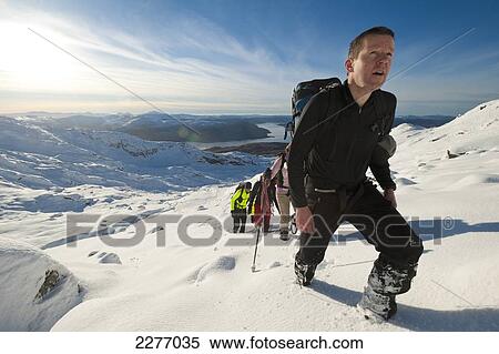 Stock Photography - Walkers going through heavy snow up Beinn Respiol, Ardnamurchan peninsula, Highlands, Scotland. Fotosearch