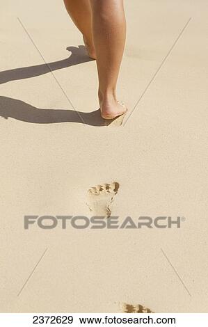 Stock Photo - Walking barefoot in the sand; Honolulu, Oahu, Hawaii, United States of America. Fotosearch