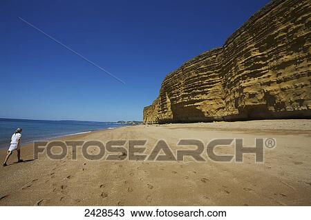 Stock Image - Walking on the beach; Dorset, England. Fotosearch