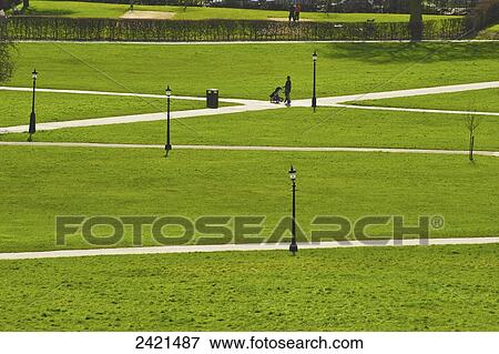 Stock Photo - Walking on the paths surrounded by lush green grass, Primrose Hill; London, England. Fotosearch
