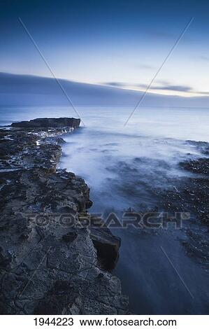 Stock Image - Water And Mist Along A Rocky Shoreline; Curio Bay South Island New Zealand. Fotosearch