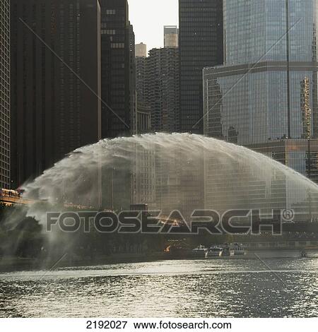 Water Spraying Over A River With Buildings In The Background; Chicago Illinois United States Of America View Large Photo Image Stock Photo - Water Spraying Over A River With Buildings In The Background; Chicago Illinois United States Of America. Fotosearch