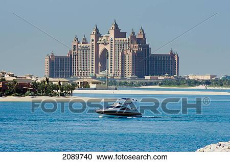 Stock Image - Watercraft With Jumeirah Palm Hotel In The Background In Dubai, Uae. Fotosearch