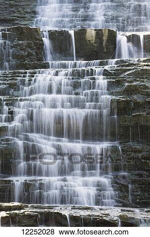 Stock Photo - Waterfalls with water flowing over steps of rock; Hamilton, Ontario, Canada. Fotosearch