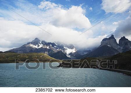 Stock Image - Waterway and mountain ranges in Torres del Paine National Park; Torres del Paine, Magallanes, Chile. Fotosearch