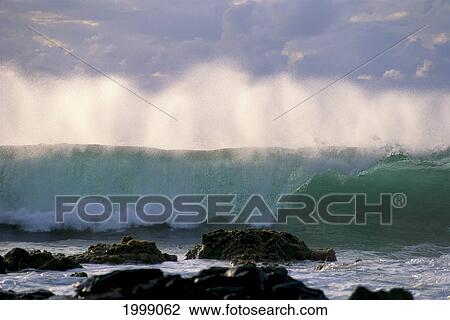 Stock Image - Wave Crashes On Rocky Shoreline, Mist On Wave B1445. Fotosearch
