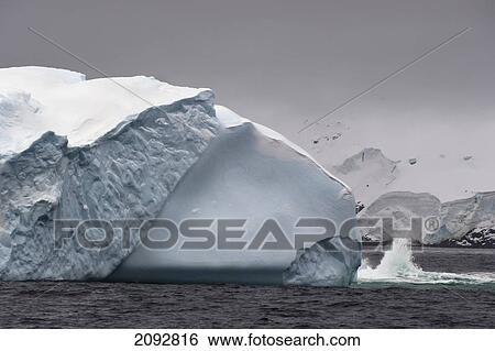 Stock Photograph - Wave Splashing Against An Iceberg; Antarctica. Fotosearch