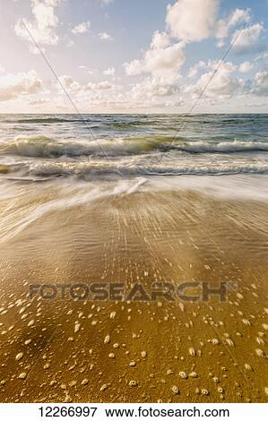 Stock Photo - Waves breaking and surf washing onto shore; Wailua, Kauai, Hawaii, United States of America. Fotosearch