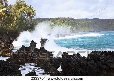 Picture - Waves crash on lava rock at sunrise; Keanae, Maui, Hawaii, United States of America. Fotosearch
