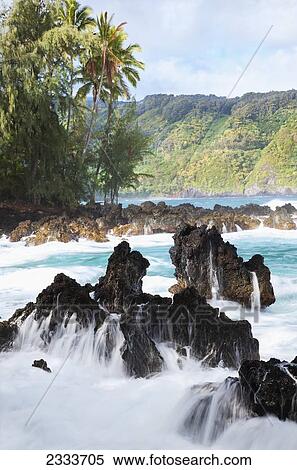 Stock Photography - Waves crash on lava rock at sunrise; Keanae, Maui, Hawaii, United States of America. Fotosearch