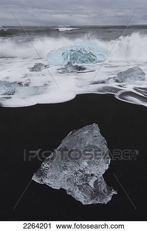 Stock Image - Waves from the atlantic ocean crash into ice calf from breioamerkurjokull a glacial tongue of the vatnajokull ice cap; iceland. Fotosearch