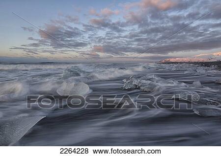 Waves of the atlantic ocean break over icebergs outside the glacial lagoon jokulsarlon; iceland View Large Photo Image Stock Photo - Waves of the atlantic ocean break over icebergs outside the glacial lagoon jokulsarlon; iceland. Fotosearch