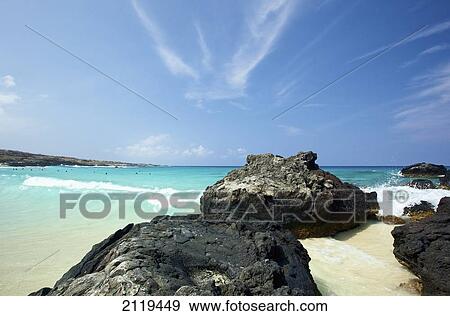 Stock Photo - Waves washing onto shore with people swimming in the ocean; Wailua, Hawaii, United States of America. Fotosearch