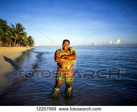 Welcoming Samoan standing outside Tanu's Beach fales; Savaii Island, Samoa View Large Photo Image Stock Photo - Welcoming Samoan standing outside Tanu's Beach fales; Savaii Island, Samoa. Fotosearch