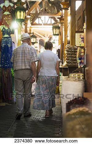 Stock Image - Western couple walking through the spice souk; Dubai, United Arab Emirates. Fotosearch