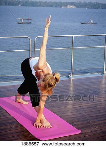 Stock Photo - Western Woman Doing Yoga On A Cruise Boat. Fotosearch