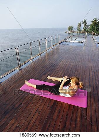 Stock Photo - Western Woman Doing Yoga On A Cruise Boat. Fotosearch