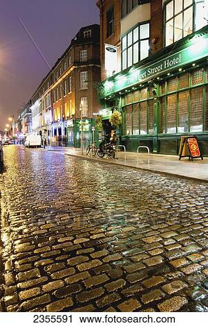 Stock Image - Wet Street And Lights Illuminating Buildings At Nighttime; Dublin, Ireland. Fotosearch