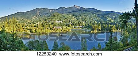 Stock Image - Whistler Mountain and Alpha Lake in the Creekside area; Whistler, British Columbia, Canada. Fotosearch