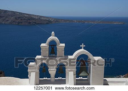 Stock Image - White bell tower of a church with view of the Aegean Sea; Firostefani, Sanotrini, Cyclades, Greek Islands, Greece. Fotosearch